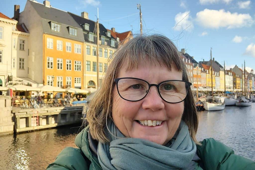 Karen, the owner of My Path To Travel stood in front of Nyhavn Canal and the colourful buildings.